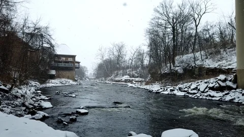 Snow falling with a river running under bridge - motion timelapse Stock Footage 101611951