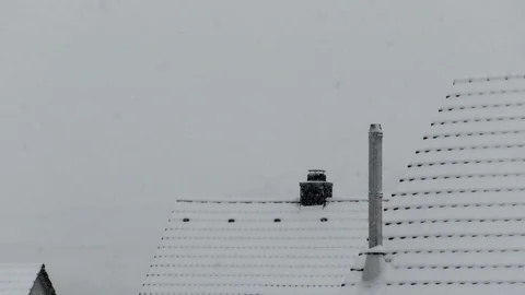 Snow falling on the rooftops of rural homes in a small German village, snowfall Stock Footage 83270129