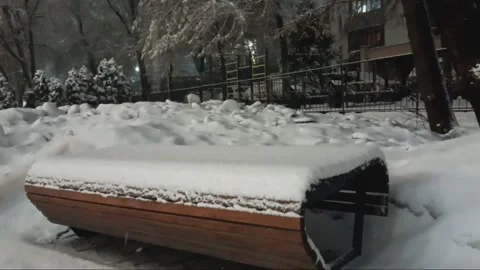 Snow falling onto seat bench in Almaty, Kazakhstan. Stock Footage 303562205
