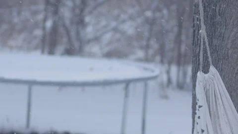 Snow falling in slow motion with a tree swing in the foreground. Stock Footage 86570660