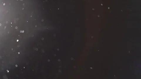 Snow falling with streetlight beams at night. Loop able snow fall background Stock Footage 84110983