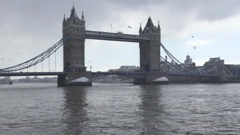 Snow falling on the Tower Bridge and the Thames River. Stock Footage 98670857