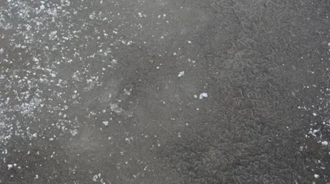 Snow falling on unfreezing water and melting Stock Footage 60355259