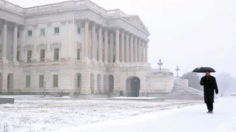 Snow Falling on US Capitol Man with an Umbrella.mp4 Stock Footage 45717903