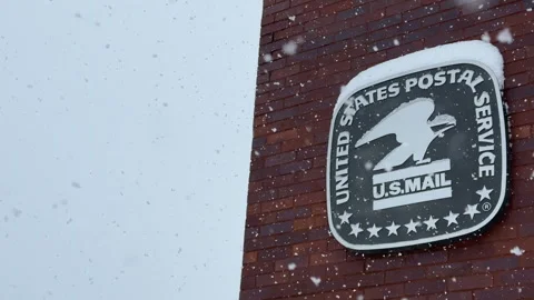 Snow falling on to a US Post office emblem Stock Footage 322645551