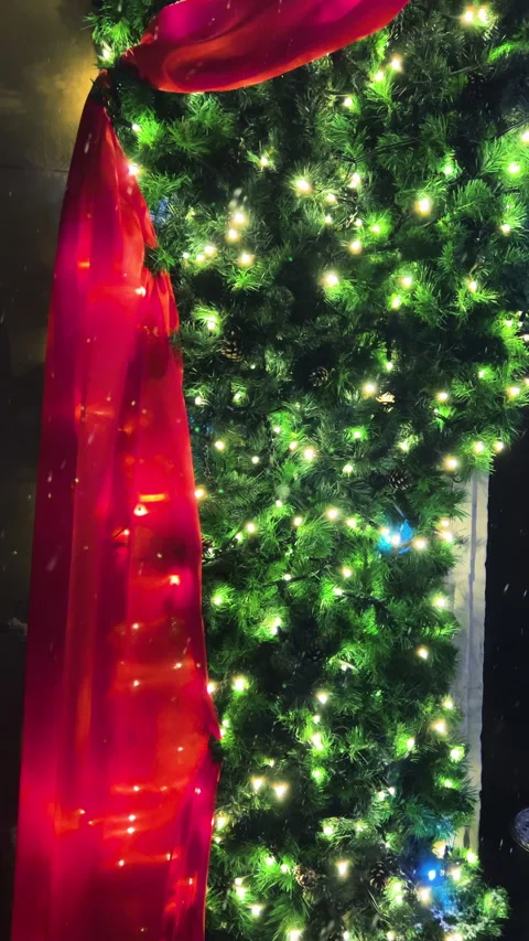 Snow falls against the backdrop of a building decorated with red fabric. 스톡 동영상 295832581