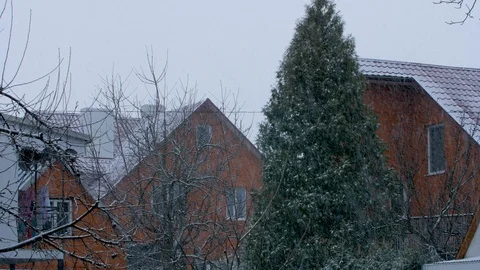 Snow falls against the backdrop of private homes Video stock 126860621