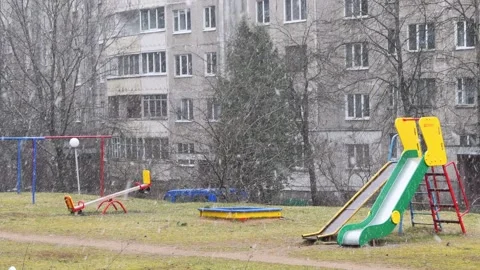 Snow falls against the background of an empty Playground, an unexpected snowfall Stock Footage 127574104