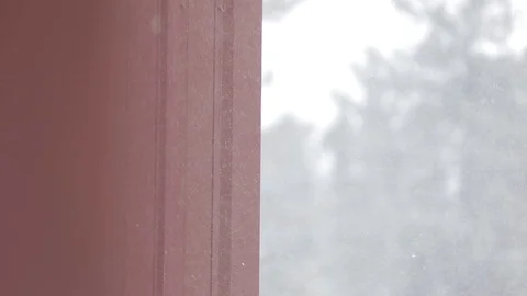 Snow falls alongside red building in Big Bear, California Stock Footage 85539343