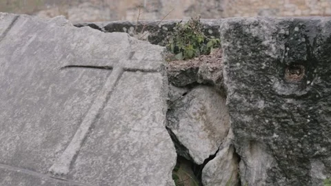 Snow falls on an ancient cross. Video stock 150600407