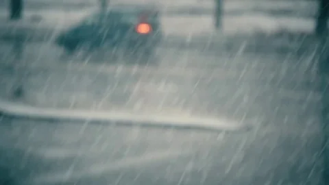 Snow falls on background of blurred road with cars Stock Footage 70031306