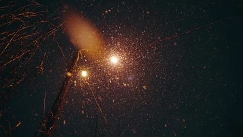 Snow falls on a background of a lantern at night, blur effect, slow motion Stock Footage 248090593