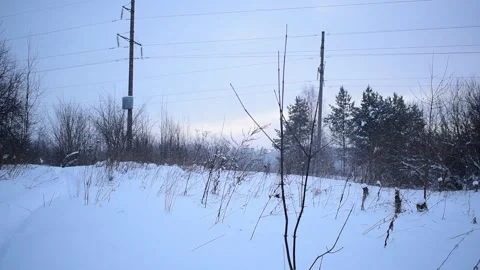Snow falls on the background of a power pole and sunrise Stock Footage 168963174