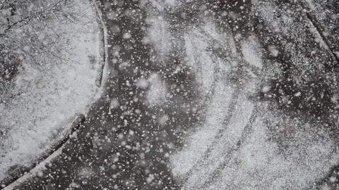 Snow falls on blurred background of road. Snowfall in the city. Stock Footage 169868153