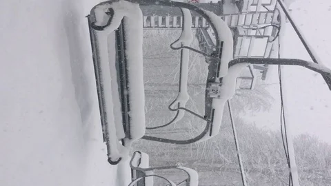 Snow falls on cable car seats in the mountains Stock Footage 124274532