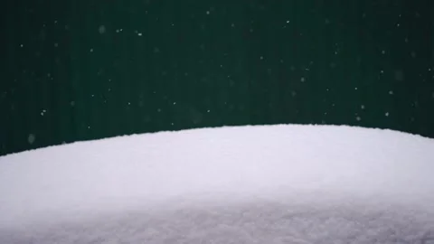 Snow falls on a green background on a white snow drift Stock Footage 227218013