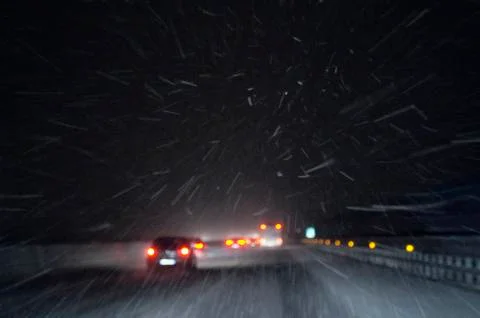 Snow falls on the highway on December night Stock Photos