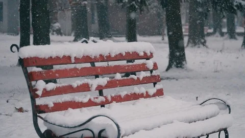 Snow falls on red bench in park when fog in winter Stock Footage 121518971