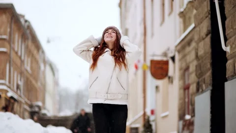 As the snow falls from the sky, a beautiful red hair woman starts playing Stock Footage 149079962