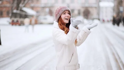 As the snow falls from the sky, a beautiful red hair woman starts playing Stock Footage 149107337