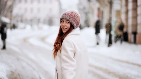 As the snow falls from the sky, a beautiful red hair woman with lovely freckles Stock Footage 166323272