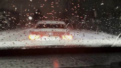 Snow falls on the windshield of the car and melts at night Stock Footage 275072723