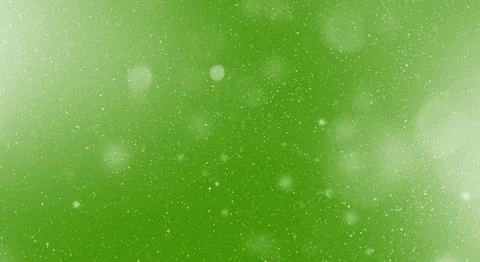 Snow flake particles on green background Stock Photos