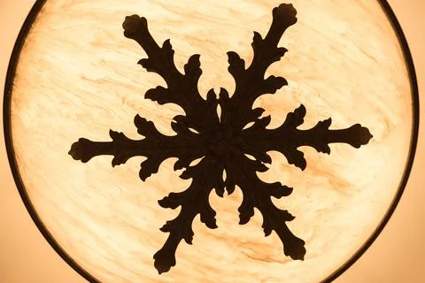 Snow flake pattern on a ceiling lamp Stock Photos