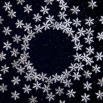 Snow flakes on dark background. Round frame made of snowflakes, place for tex Stock Photos