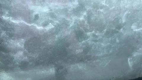 Snow flakes falling on a glass window, snow gliding and melting across glass Stock Footage 263289796