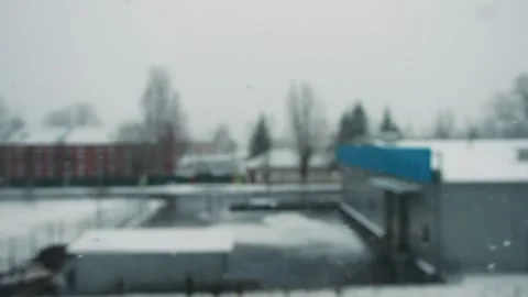 Snow flakes in winter on a cloudy day against the background of a building. Slow Stock Footage 253472070