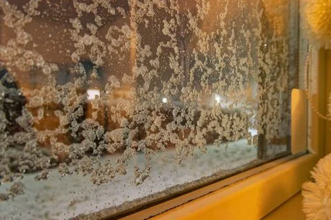 Snow flecks on window, plush bear peeks from the sill Foto stock