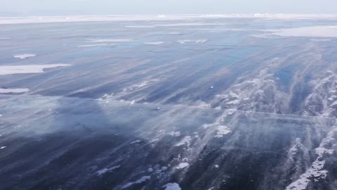 Snow is flying over surface of blue ice of Lake Baikal Video stock 149563405
