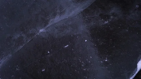 Snow is flying over surface of ice. Footage. Snowflakes fly on ice of Lake. Ice Stockbeeldmateriaal 129981792