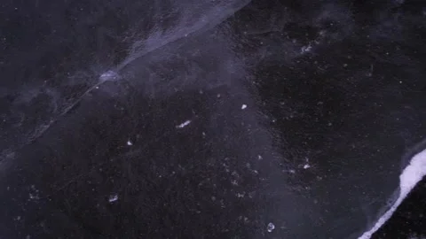Snow is flying over surface of ice. Footage. Snowflakes fly on ice of Lake Stockbeeldmateriaal 131029141