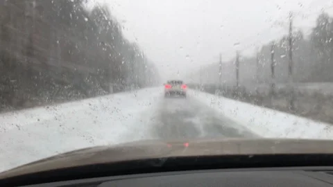 Snow flying at windshield while car driving at winter Stock Footage 98980423