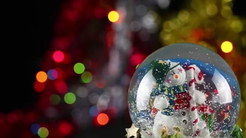 Snow globe with snowman and candy canes, set against colorful holiday bokeh Stock Footage 222033770