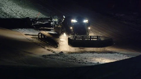 Snow groomer machine rides up mountain at night Stock Footage 116786232