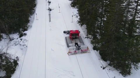 Snow groomer preparing the snow in a ski lift one late afternoon in the spring Video stock 150892177
