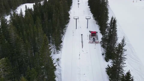 Snow groomer preparing the snow in a ski lift one late afternoon in the spring Stock Footage 150892280