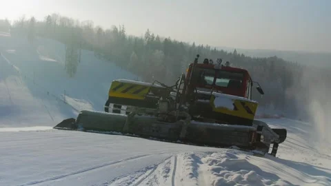 Snow Grooming Tractor Starts Down the Hill Preparing the Ski Slope Stock Footage 291323631