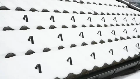 Snow guards, retainers  or snow hooks on the tile roof covered by snow Video stock 297619845