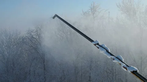 Snow gun making artificial snow in morning, on back fir forest. Snowmaking by Stock Footage 166796646