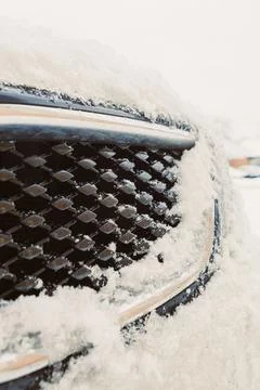 Snow has built up on the front grille of a parked car in a neighborhood durin Foto stock
