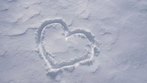 Snow heart. Romantic winter pattern. Heart shape in snow. Stock Photos