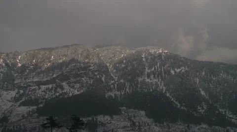 Snow heavy clouds rush in over snow-covered mountain Video stock 10821081