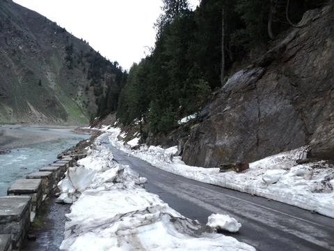 Snow-Lined Mountain Road Alongside a River in Northern Pakistan Stock Photos