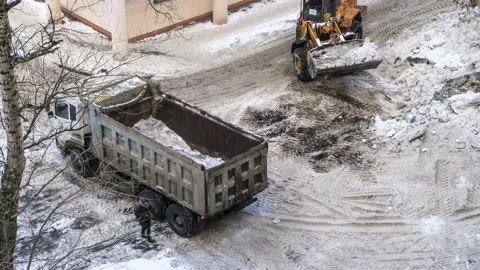Snow loading by road machinery after heavy snowfall in residential block, tim Stock Footage 86260559