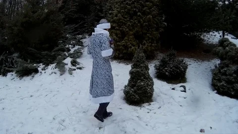 Snow Maiden in forest puts presents toys under a firm pine tree smiling Ukraine Stock Footage 71014921