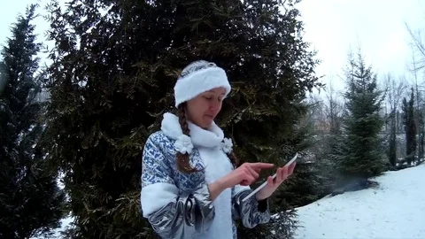 Snow Maiden in forest with tablet computer in front of firm pine tree smiling Stock Footage 71015973